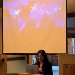 Katharine Hayhoe stands before a night-time photograph of the Earth at Chapel by the Lake on Sept. 13, 2019. (Peter Segall | Juneau Empire)