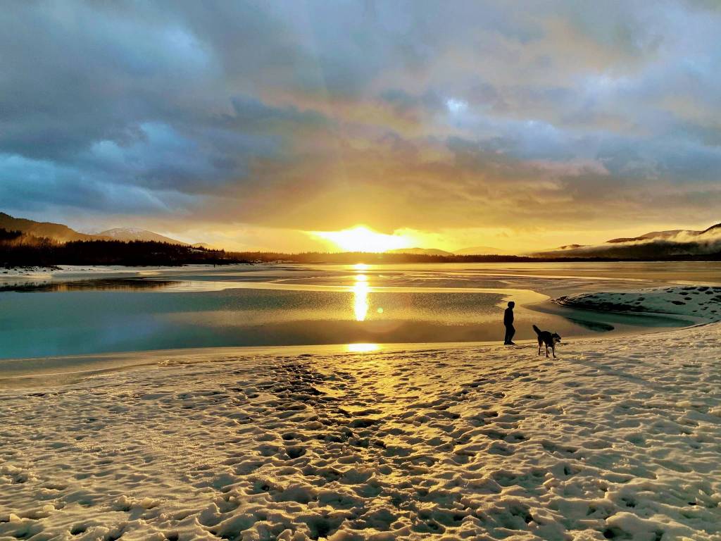 Karson Leamer and his dog, Piper, watch the sunset across Mendenhall Lake on Thanksgiving Day 2020. (Courtesy Photo / Christena Leamer)