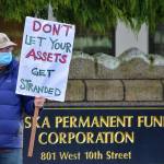 Mike Tobin of environmental group 350Juneau demonstrated outside the Alaska Permanent Fund Corporation building on Wednesday, Dec. 9, 2020. APFC's Board of Trustees were having their quarterly meeting inside and group members submitted testimony urging divestment from fossil fuels and other assets potentially impacted by climate change. (Peter Segall / Juneau Empire)