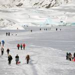 Walkers head across the frozen Mendenhall Lake to the ice caves at the glacier on Feb. 11, 2021. (Courtesy Photo / Kenneth Gill, gillfoto)