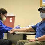 Fritz Moser, 63, waits while registered nurse Lori Higgins test his blood sample for glucose and cholesterol levels at a free screening clinic on Saturday, Nov. 6, 2021, at Bartlett Regional Hospital. The hospital used to hold regular health clinics to stress the importance of preventive health care but those had to close with the COVID-19 pandemic. (Peter Segall / Juneau Empire)