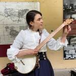 Annie Bartholomew prepares her banjo for rehearsal for her Victorian folk opera, Sisters of White Chapel, at the Treadwell Mine Office on July 5, 2022. (Michael S. Lockett / Juneau Empire)