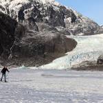 Skiers cross the frozen lake in front of the Mendenhall Glacier in December. A proposed expansion of the Mendenhall Glacier Recreational Area by the U.S. Forest Service envisions motorized tour boat access in most alternatives, but the three newest ones based on previous public feedback limit vessels to low-impact electronic access or none. (Clarise Larson / Juneau Empire)