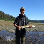 Beebuks Kookesh stands with a salmon he caught with his hands in a stream on Admiralty Island. He released it back into the water. (Courtesy Photo / Mary Catharine Martin)