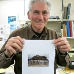 George Plafker holds up a photo of uplifted Alaska shorelines he took after visiting the southern coast following the March 1964 magnitude 9.2 earthquake. Plafker was standing in his office in Menlo Park, California, when this photo was taken in 2013. (Photo by Ned Rozell)