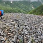 Adam Bucki hauls a load of trash from Fireweed rock glacier to the site where a helicopter will pick it up and haul it back to nearby McCarthy. He would later dispose of the trash in a sanitary landfill. (Photo by Ned Rozell)