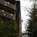 A worker dangles high on the exterior of the State Office Building while washing it Thursday morning. (Mark Sabbatini / Juneau Empire)