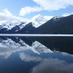 The sky and mountains are reflected in the water on April 5, 2012, at the Kootznoowoo Wilderness in the Tongass National Forests Admiralty Island National Monument. Conservation organizations bought some private land and transferred it to the U.S. Forest Service, resulting in an incremental expansion of the Kootznoowoo Wilderness and protection of habitat important to salmon and wildlife. (Photo by Don MacDougall/U.S. Forest Service)