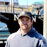 Scotty Switzer, 36, poses for a photo on his boat at the Homer harbor. (Nathaniel Herz/Northern Journal)