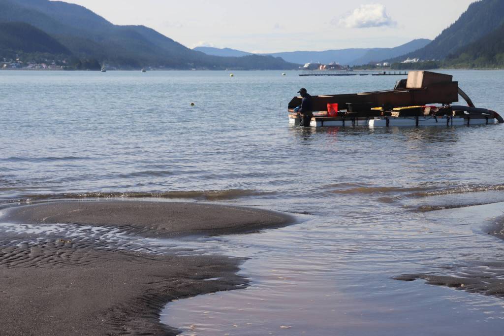 Ernest Hart pulls his suction dredge closer to shore as the tide comes in. In the background are DIPACs hatchery floats. (Jasz Garrett / Juneau Empire)