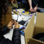 Hoonah Alaska Youth Stewards crew members plug sensors into WeatherChime environmental monitoring devices. (Photo by Zofia Danielson)