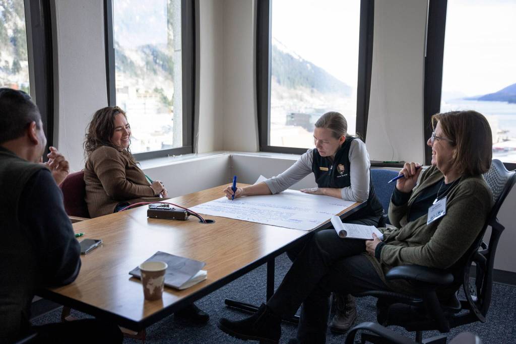 Brainstorming in a breakout group during a 2023 visioning session hosted by the U.S. Forest Services Alaska Region. The convening brought together thirty representatives from federal agencies, leaders from Central Council Tlingit and Haida Indian Tribes of Alaska (CCTHIA), and regional organizations to focus on the Southeast Alaska Sustainability Strategy and the future of land management and rural economic development in the region. From left to right: Raymond Paddock III (CCTHIA), Alana Peterson (Spruce Root), Sara Doyle (National Park Service, Glacier Bay National Park), and Ann Fischer (U.S. Natural Resources Conservation Service). (Photo by Lee House)