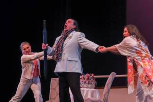 Gabriel von Eisenstein (David Cangelosi) is pulled in two separate directions by his wife Rosalinda (Sara Radke Brown, right) and Rosalindas maid, Adele (Kayla Kohlhase, left) during a dress rehearsal of Die Fledermaus on Wednesday, March 12, 2025. (Jasz Garrett / Juneau Empire)