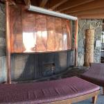 Copper sheathed fireplace with visible bullet dents created when windows were shot at the Mendenhall Glacier Visitor Center in the mid-1980s. (Photo by Laurie Craig)