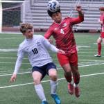 Juneau-Douglas High School: Yadaa.at Kalé sophomore Sam Mazon (4) heads a ball over Soldotna freshman Trevin Moore (18) during the Crimson Bears 3-0 win over the Stars on Thursday at Adair Kennedy Memorial Park. (Klas Stolpe / Juneau Empire)