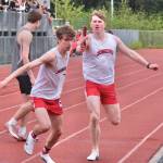 Juneau-Douglas High School: Yadaa.at Kalé senior Nick Iverson receives the 4x400 baton from classmate Finn Lamb during the Crimson Bears’ win in the final event of the Region V Championships on Saturday at Thunder Mountain Middle School. (Klas Stolpe / Juneau Empire)