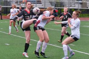 Juneau-Douglas High School: Yadaa.at Kalé senior Ella Orsborn (9) wins a ball against Wasilla as senior teammate Adelyn Buss (3) moves in during the Crimson Bears senior appreciation game Saturday at Adair-Kennedy Memorial Park. (Klas Stolpe / Juneau Empire)