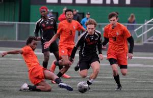 Juneau-Douglas High School: Yadaa.at Kalé senior Kai Ciambor (14) moves the ball against West Anchorage senior Amine Abakar, left, Michael Njoku and Porter Youngman. during the Crimson Bears 3-2 loss in extra time to the Eagles in the 2025 ASAA/First National Bank Alaska Soccer State Championship semifinals Friday at Wasilla High School. (Klas Stolpe / Juneau Empire)
