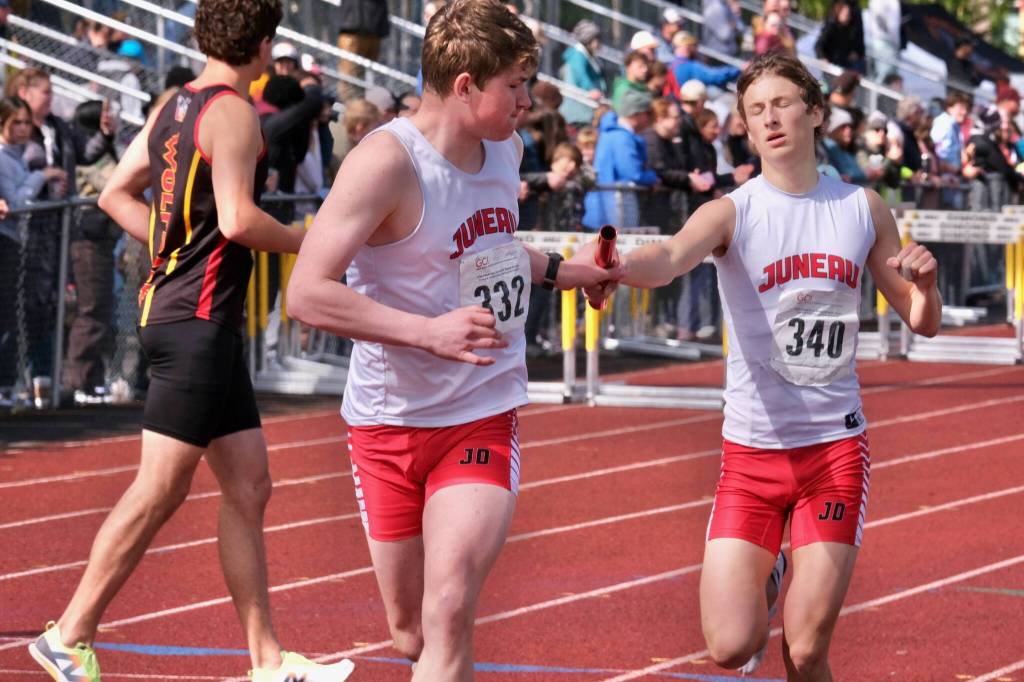 Juneau-Douglas High School: Yadaa.at Kalés Finn Lamb takes the baton from Ferguson Wheeler in the boys 4x800 relay during the 2025 ASAA/First Bank Alaska State Track & Field Championships on Saturday at Anchorages Dimond High School. (Klas Stolpe / Juneau Empire)