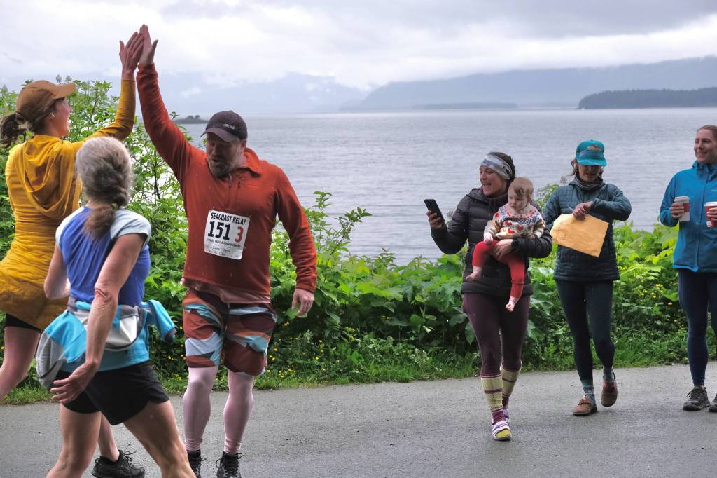 Team Babes With Babies make a handoff at the Auke Village Recreation Area during the Seacoast Relay on Sunday, June 8, 2025. (Klas Stolpe / Juneau Empire)