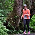 Team JACKD runner Claire Geldhof races on Auke Lake Trail in the first leg of the Seacoast Relay on Sunday, June 8, 2025. (Klas Stolpe / Juneau Empire)