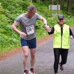 Team JACKDs Dan Robinson takes the hand off from Kim Campbell at Lena Beach Picnic Area during the Seacoast Relay on Sunday, June 8, 2025. (Klas Stolpe / Juneau Empire)