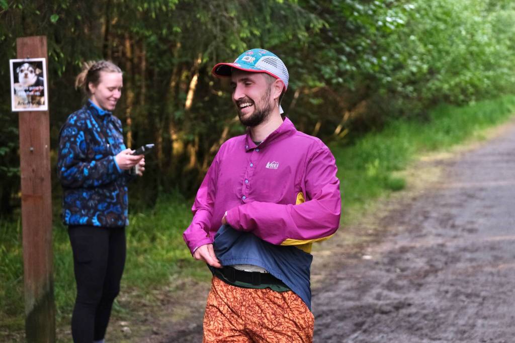 David Fure finishes the East Glacier Trail Tangle on Tuesday as race director Therese Pokorney records his time. The 4.9-mile race follows part of Under Thunder Trail around East Glacier Trail and back. (Klas Stolpe / Juneau Empire)