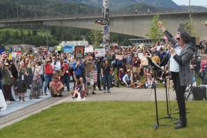 Christina Love leads the audience in raising their fist, symbolizing telling the truth despite fear on Saturday, June 14, 2025. (Natalie Buttner / Juneau Empire)