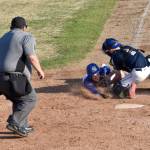 Photo by Jeff Helminiak / Peninsula Clarion
Xzavier Martin of Madisonville (Kentucky) Post 6 scores against Noah Lewis of Auke Bay Post 25 on Friday in the Lance Coz Wood Bat Tournament at Coral Seymour Memorial Park in Kenai .