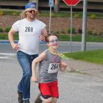 Richard (right) and Doryn Goudie make a mad dash for the finish on Friday, June 20, 2025. (Natalie Buttner / Juneau Empire)