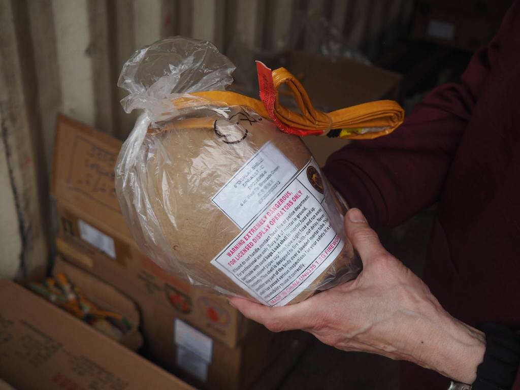 Sigrid Dahlberg carefully holds an 8-inch firework on Thursday, July 3<ins>,</ins> <ins>2025</ins>. (Natalie Buttner / Juneau Empire)