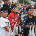 Triplets Lawrence, Liam, and Logan David wait excitedly for the next float to pass by them during the 2025 downtown Juneau Fourth of July Parade. (Natalie Buttner / Juneau Empire)