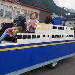 Kids throw candy from the Alaska Marine Highway Crew float, a part of the Juneau Central Labour Council submission. (Natalie Buttner / Juneau Empire)