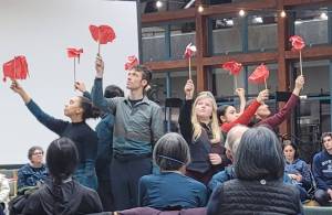 Actors in These Birds, a play inspired by death, flowers and Farkle, hold flowers during a performance at the UAS Egan Library on Saturday, Jan. 31. (photo courtesy Claire Richardson)