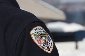A police officer stands on duty in early March. The Juneau Police Department say two residents are faces charges related to drug offences. (Clarise Larson/Juneau Empire File)